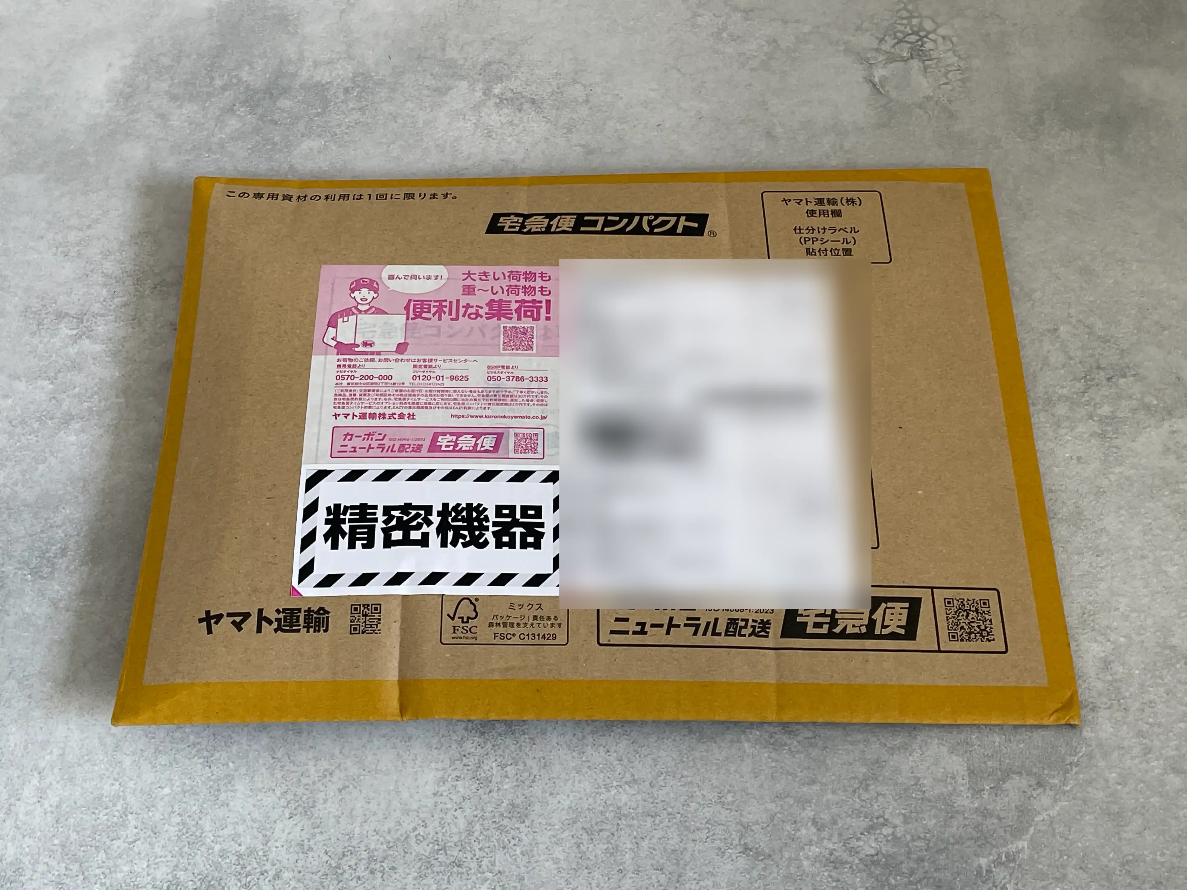 イオシスからGoogle Pixel7aが届いた宅急便コンパクトの箱。「精密機器」のシールが貼られている