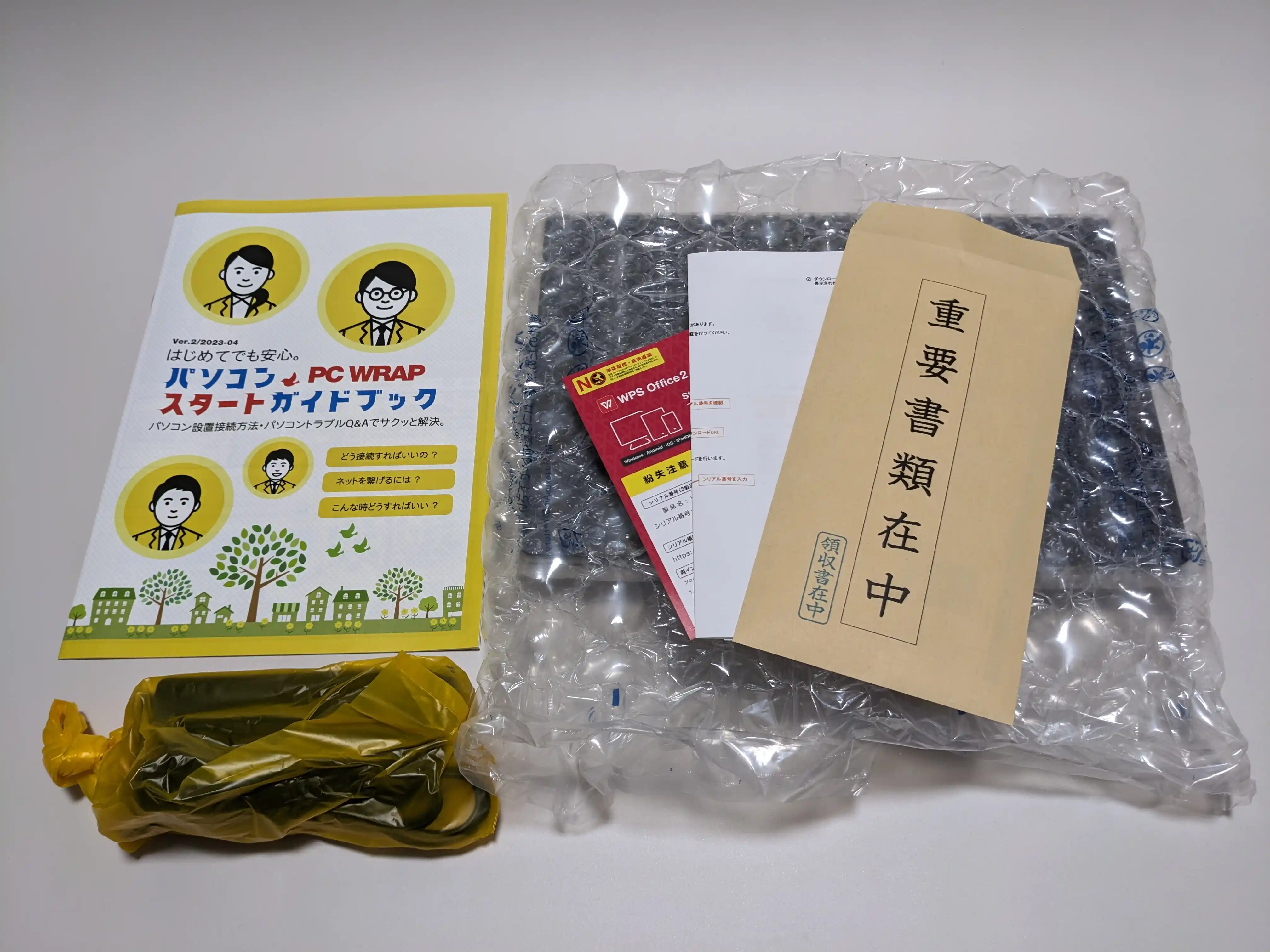 PC WRAPのパソコンスタートガイドブックとWPS Office 2のカード、重要書類在中の封筒